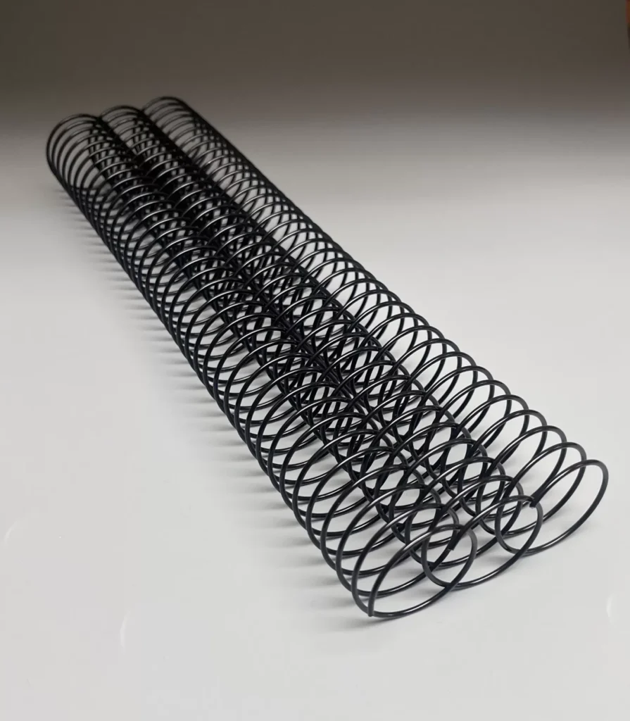 Three Wire Spiral Coils are aligned horizontally on a reflective white surface.