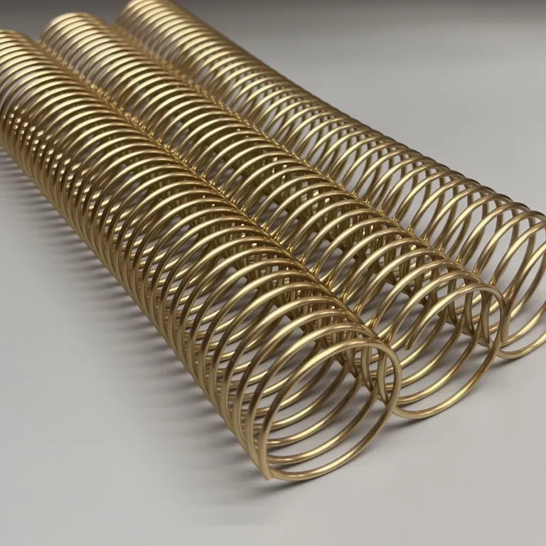 A single 1+1/2" x 10" #4 PEL Gold Solid Spiral Aluminum piece lies aligned parallel on a plain gray surface.